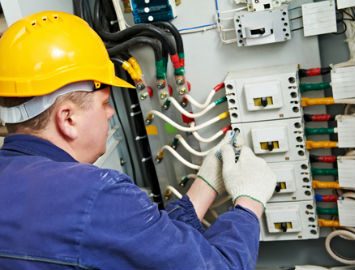 tradesman working on electrical system in ppe