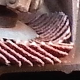 Close up of flap disc being used against steel beam